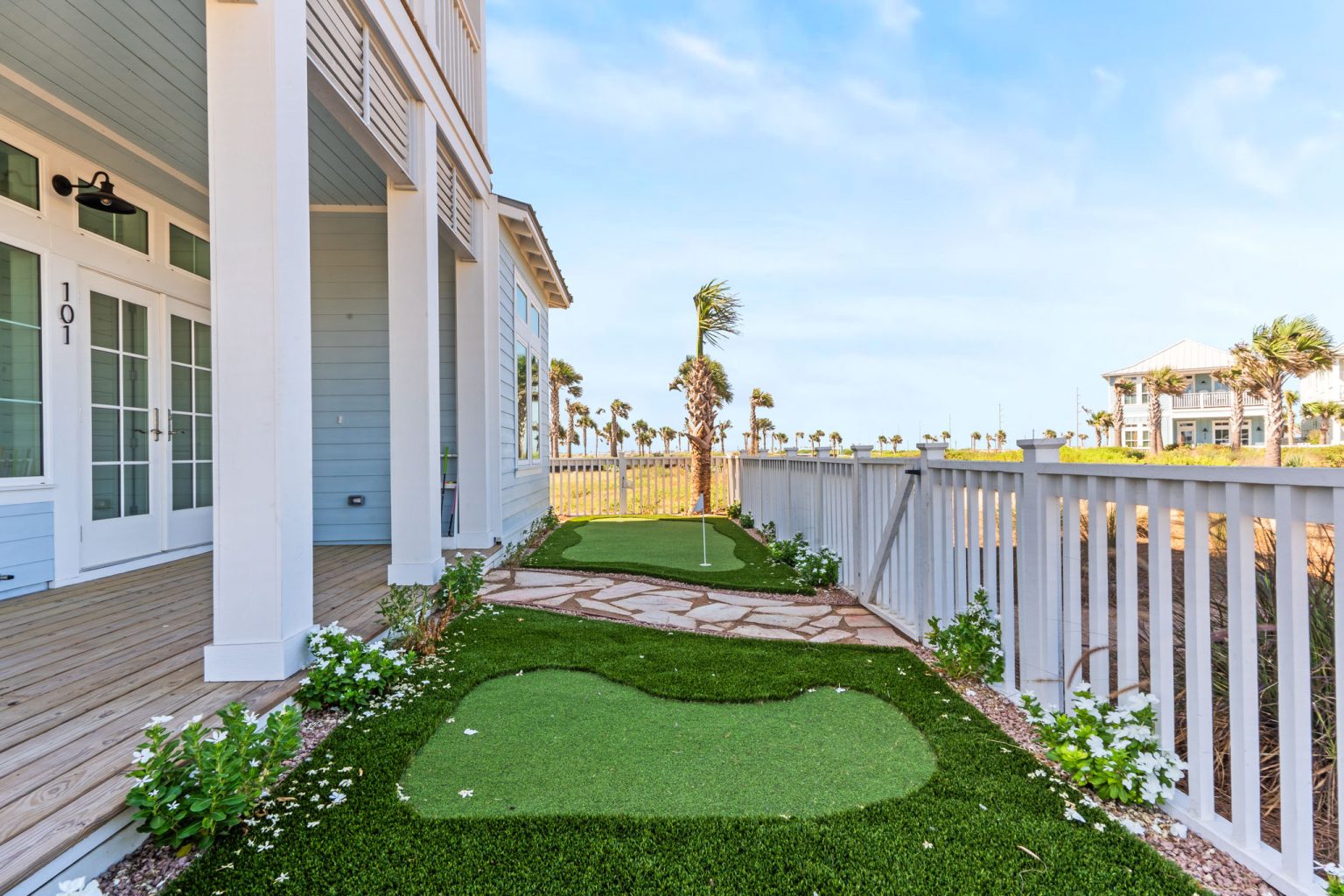 Side yard with a putting green along the porch at 101 Sea Whip Lane