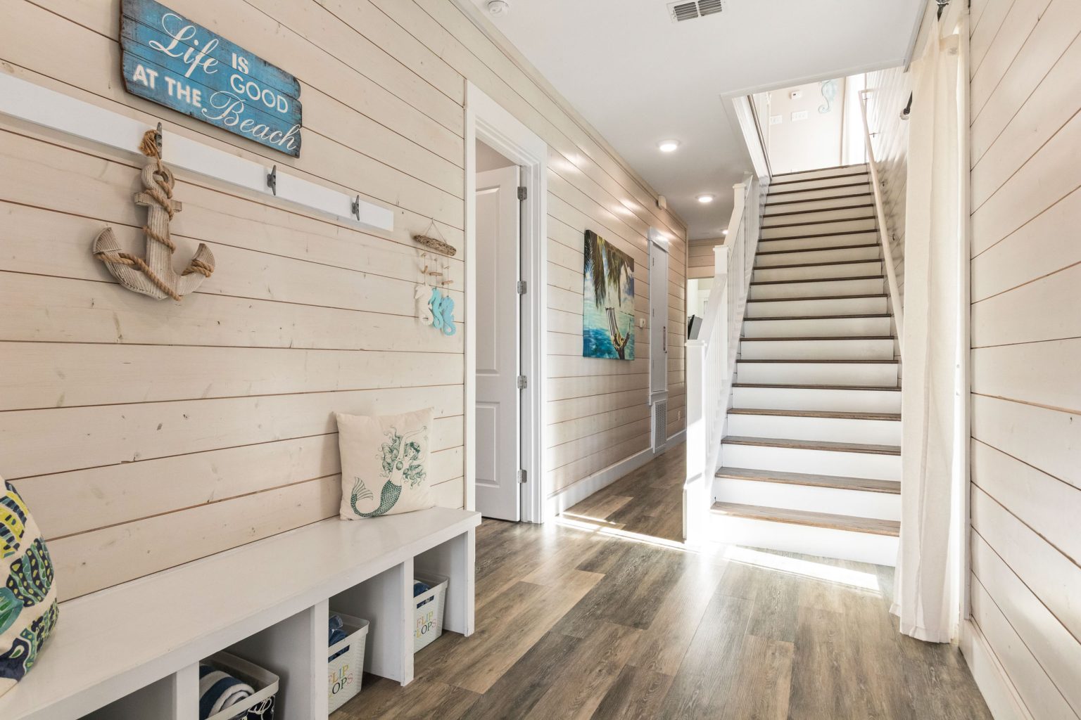 Entry hall with shiplap walls, bench and staircase at 152 Sea Rocket Lane