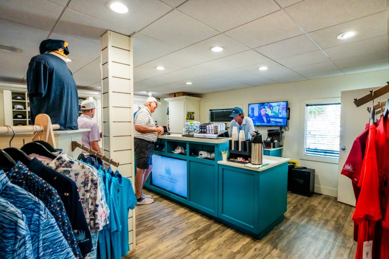 Guests browsing apparel at the counter of the Palmilla Beach pro shop