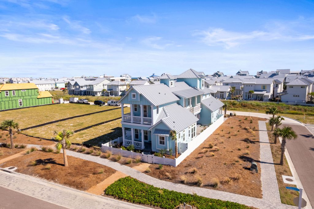 Aerial view of 724 Sunset Avenue, a light blue single-family home at Palmilla Beach