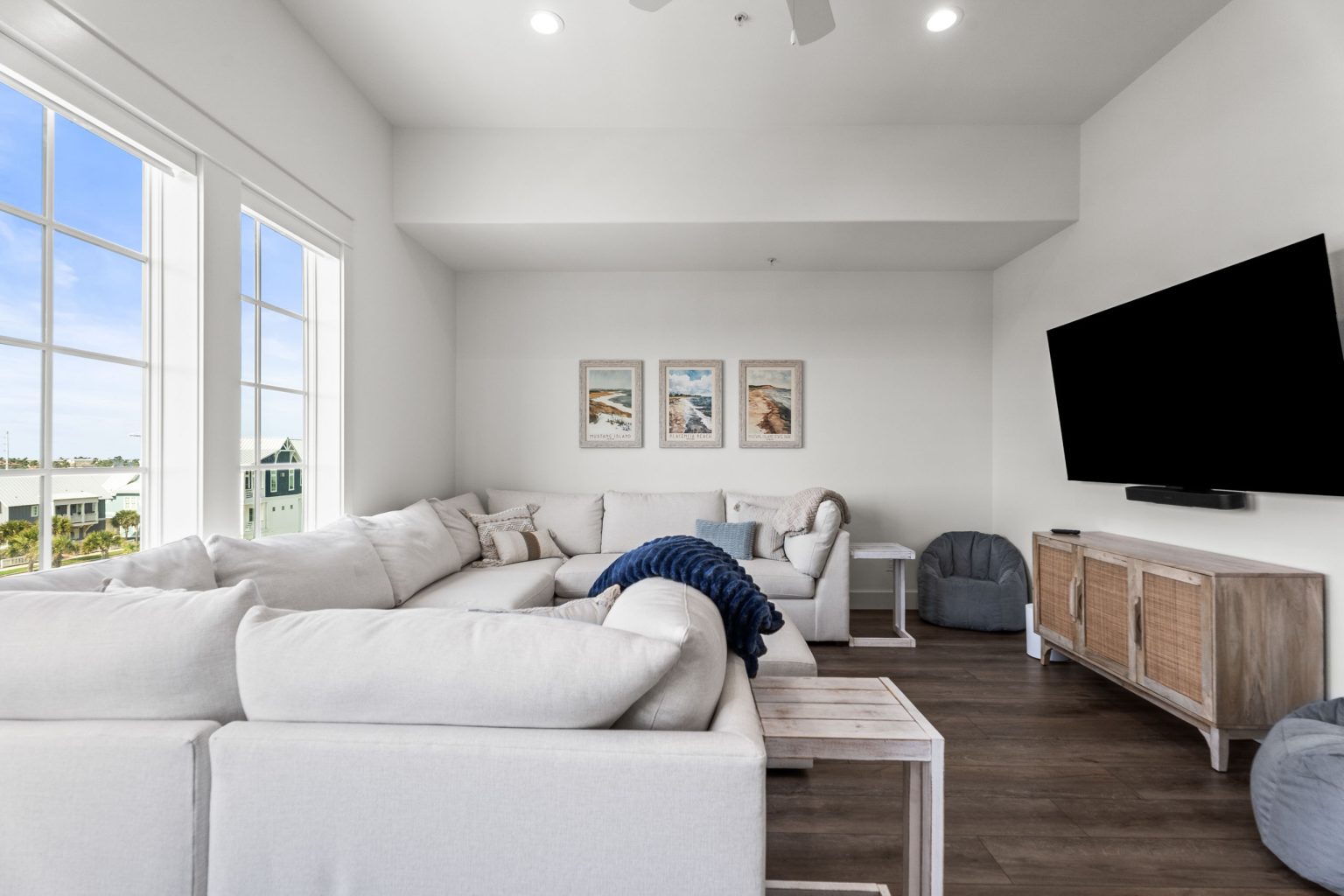 Media room with a white sectional and bright windows at 250 Sunrise Avenue