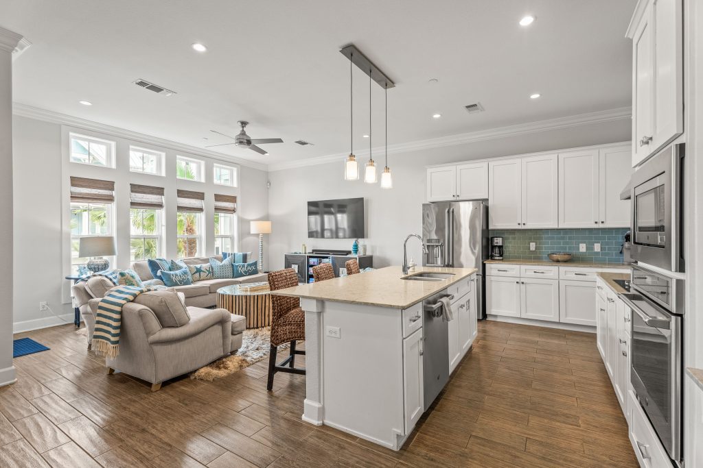 Open kitchen and living room with a white island and pendant lights at 137 Palmilla Circle #204