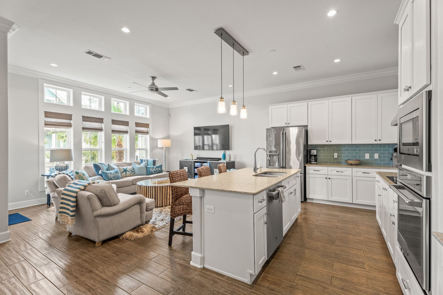 Open kitchen and living room with a white island and pendant lights at 137 Palmilla Circle #204
