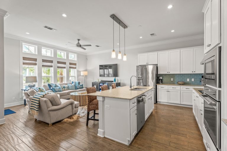 Open kitchen and living room with a white island and pendant lights at 137 Palmilla Circle #204