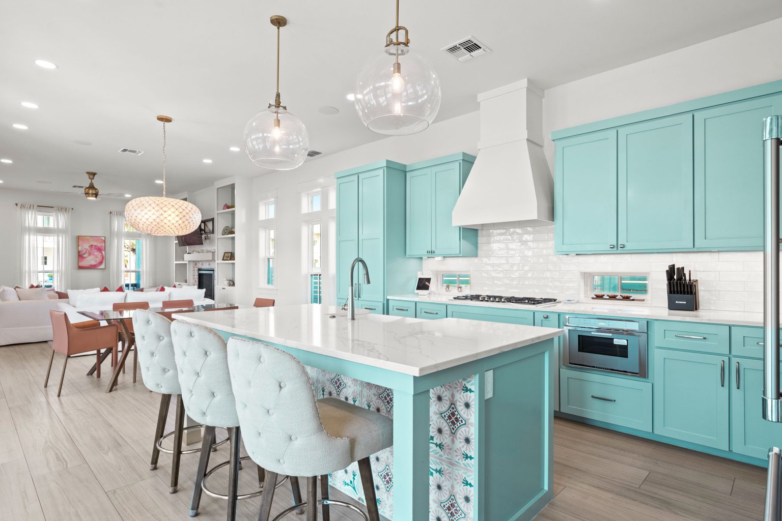 Kitchen with aqua cabinets, a large island and tufted barstools at 724 Sunset Avenue
