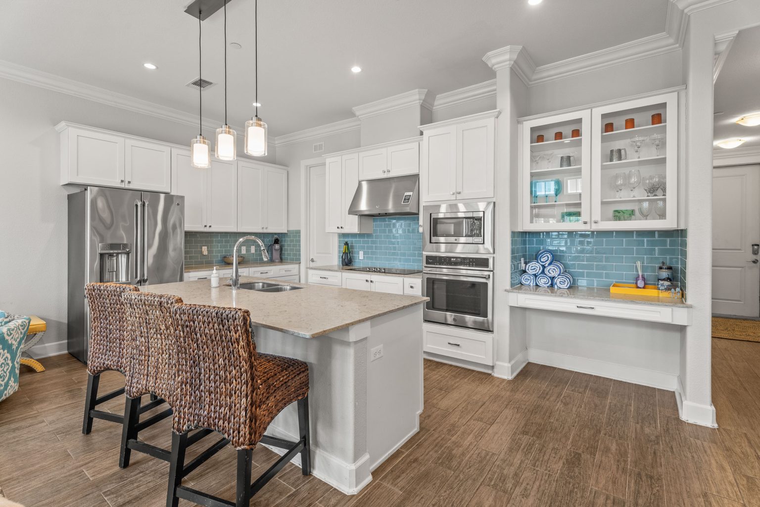 Kitchen with white cabinets, blue tile backsplash and island seating at 137 Palmilla Circle #204