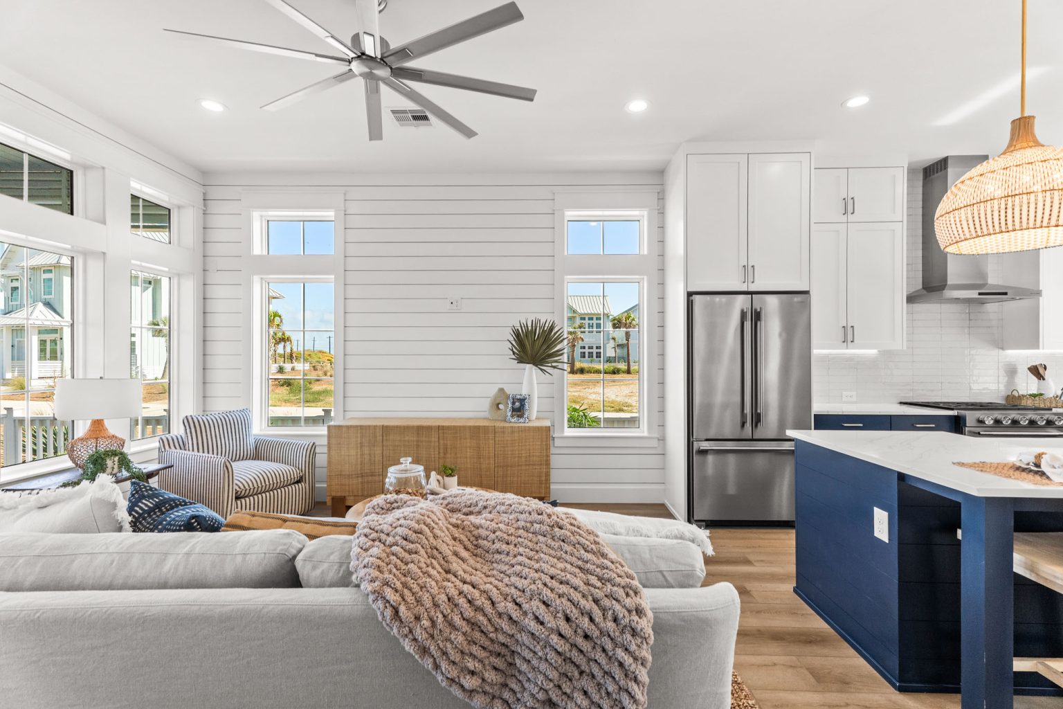 Living room open to a kitchen with a navy island at 101 Sea Whip Lane