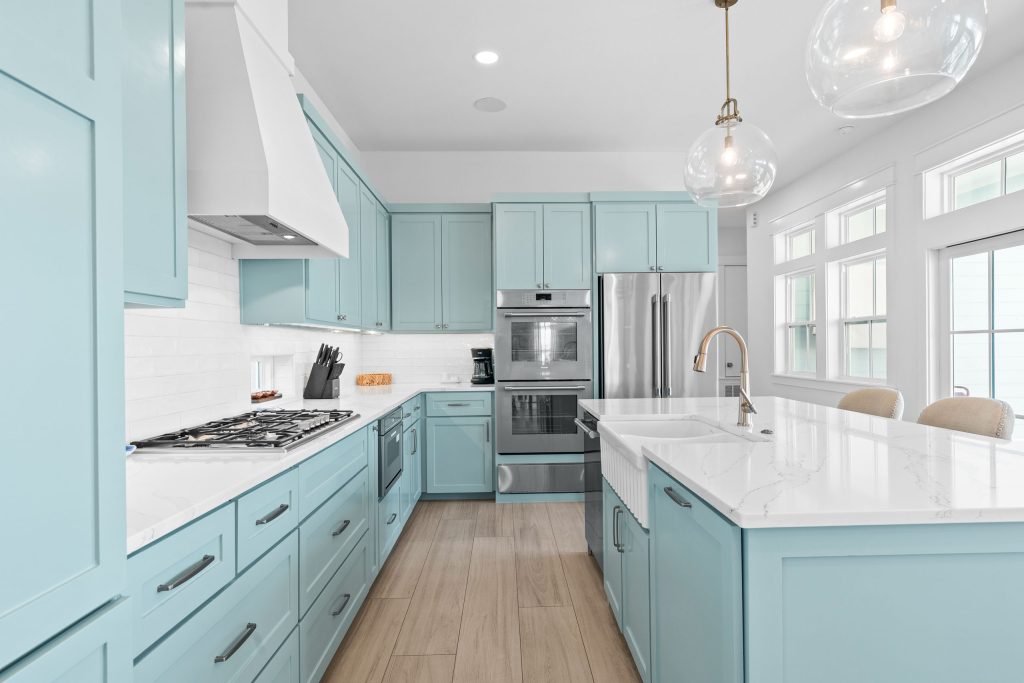 Kitchen with aqua cabinets, gas cooktop and double wall ovens at 724 Sunset Avenue