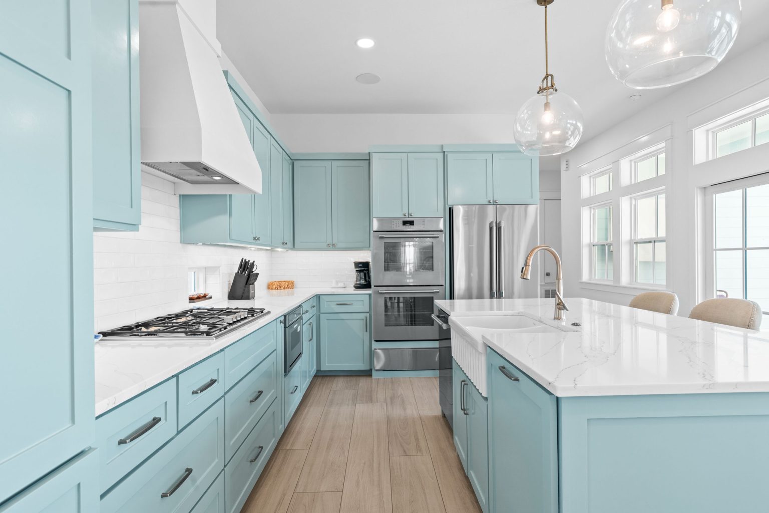 Kitchen with aqua cabinets, gas cooktop and double wall ovens at 724 Sunset Avenue