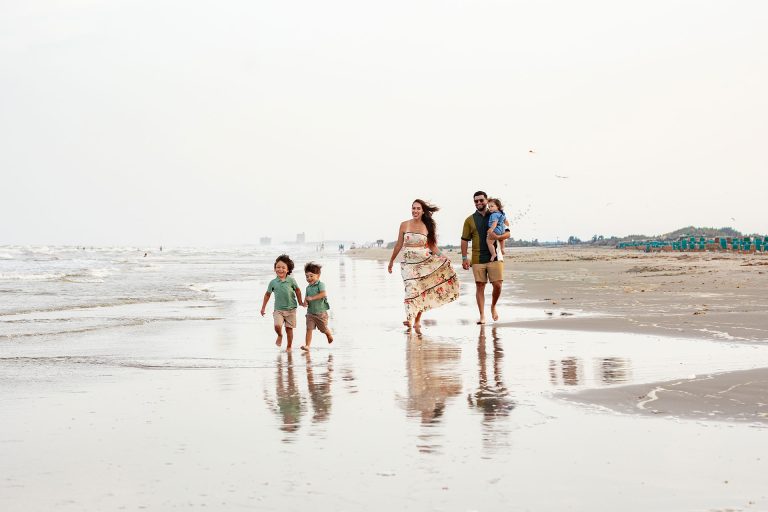 Family walking along the wet sand at low tide