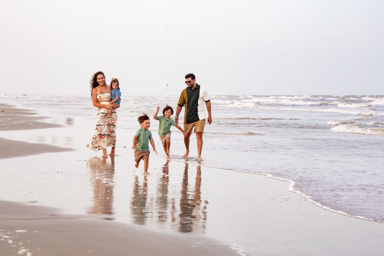 Family walking along the shoreline at Palmilla Beach