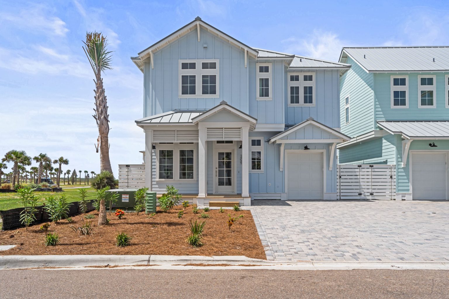 Front of 205 Horse Tail Lane, a light blue two-story home with a garage at Palmilla Beach
