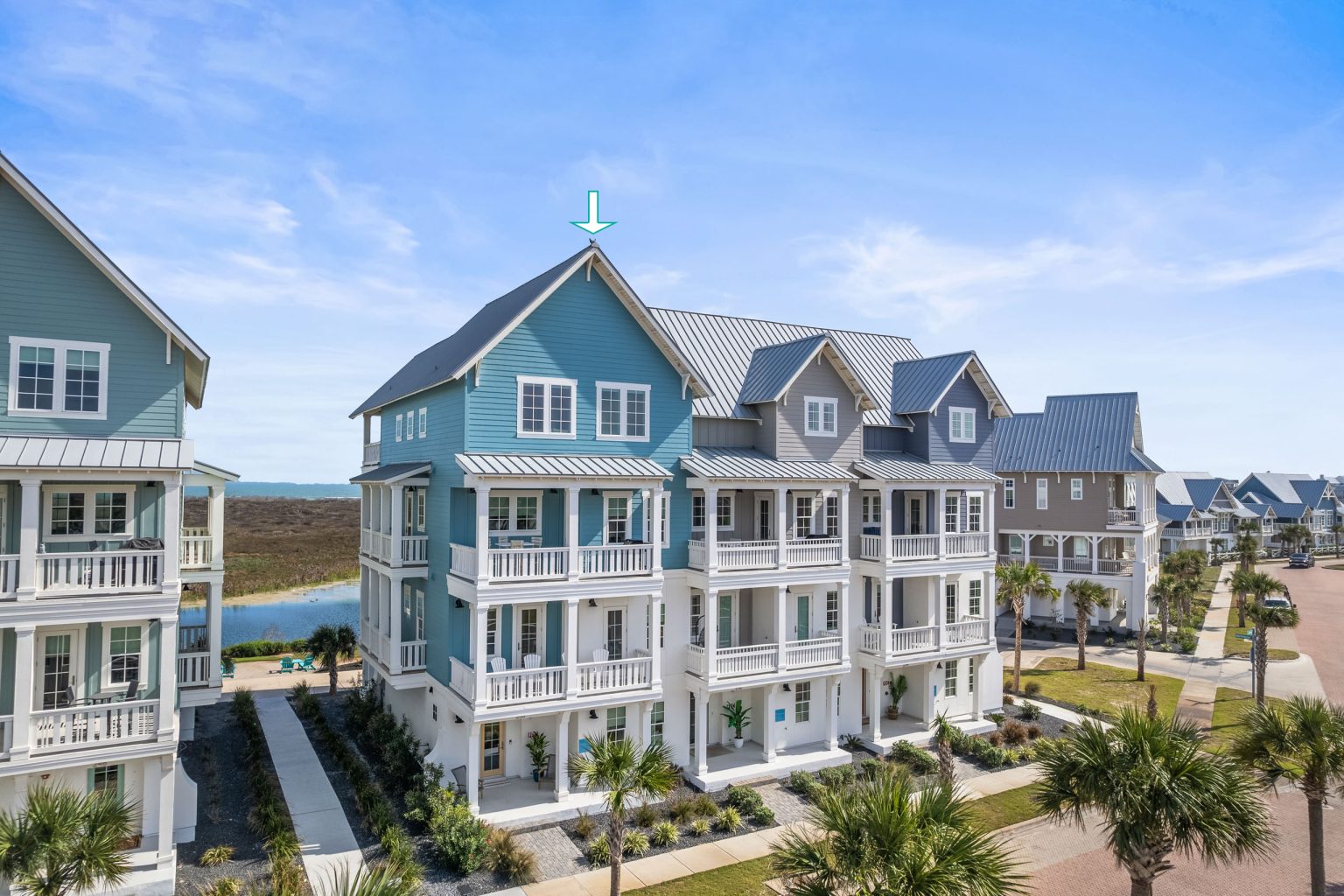Exterior of the blue townhomes at 250 Sunrise Avenue with stacked porches at Palmilla Beach