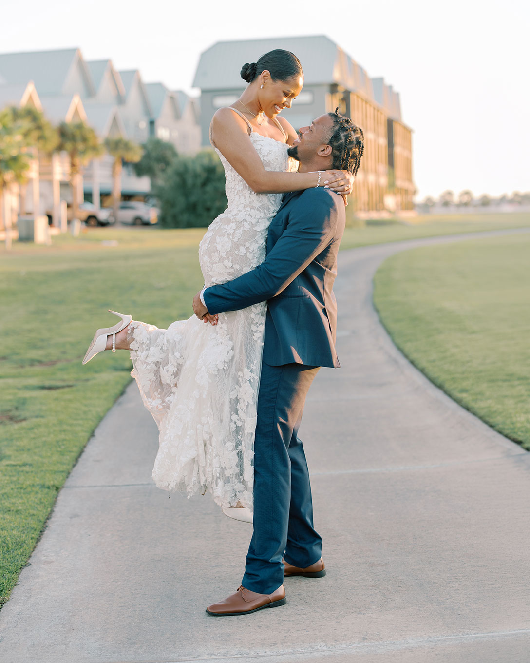 Groom lifting the bride on a path beside Palmilla Beach homes