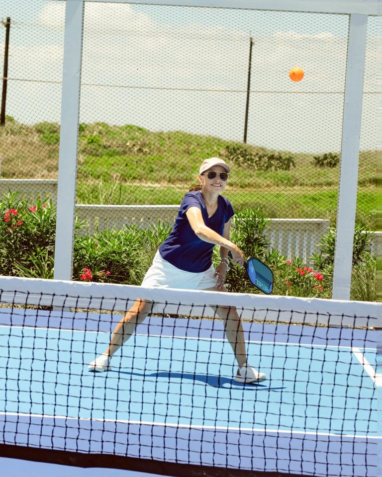 Woman playing pickleball on the Palmilla Beach court