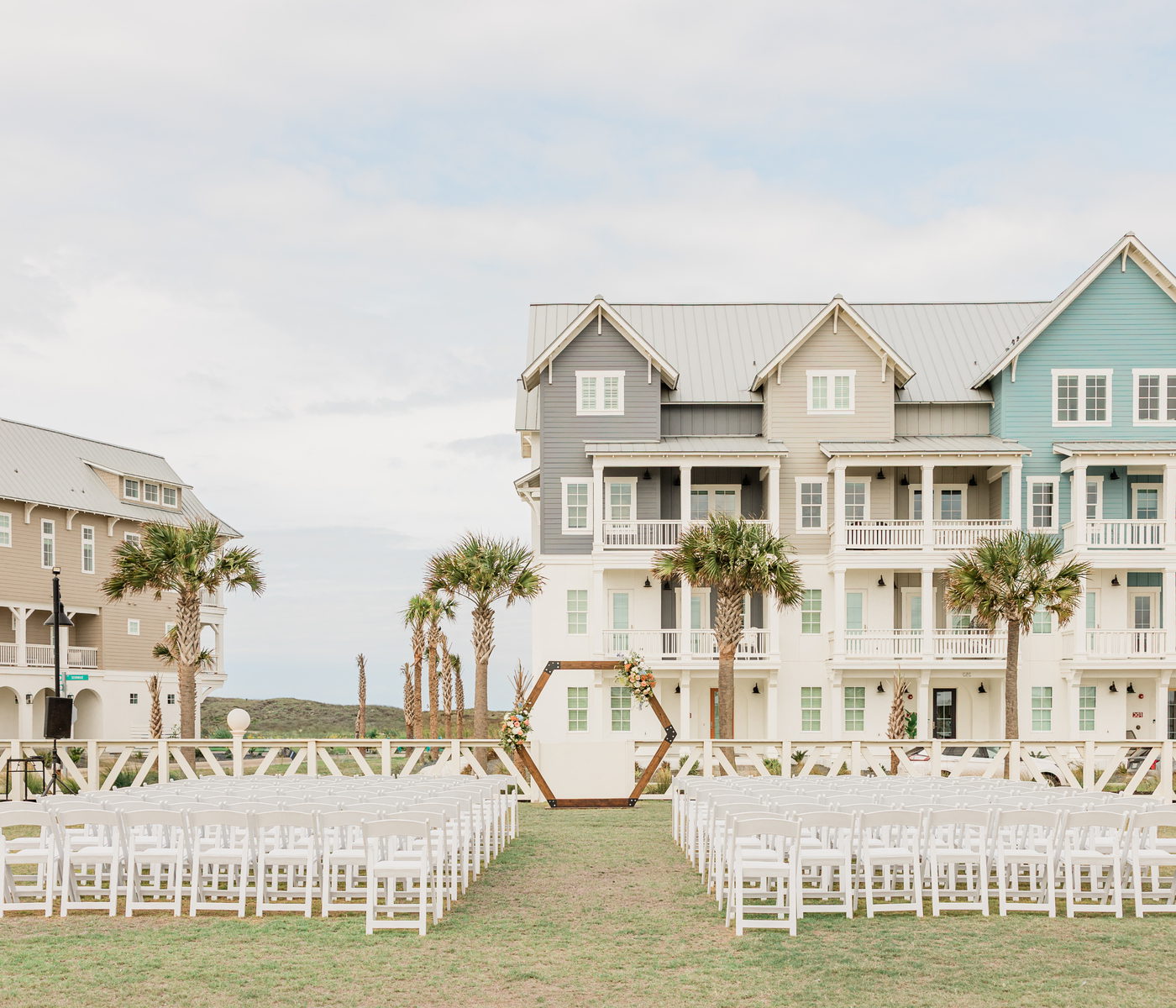 Outdoor wedding ceremony set-up with a hexagon arch in front of Palmilla Beach homes