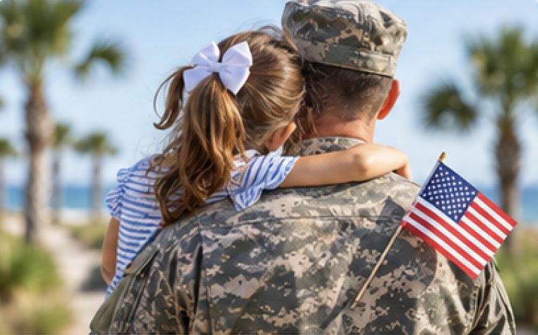 Service member in uniform holding a child with an American flag