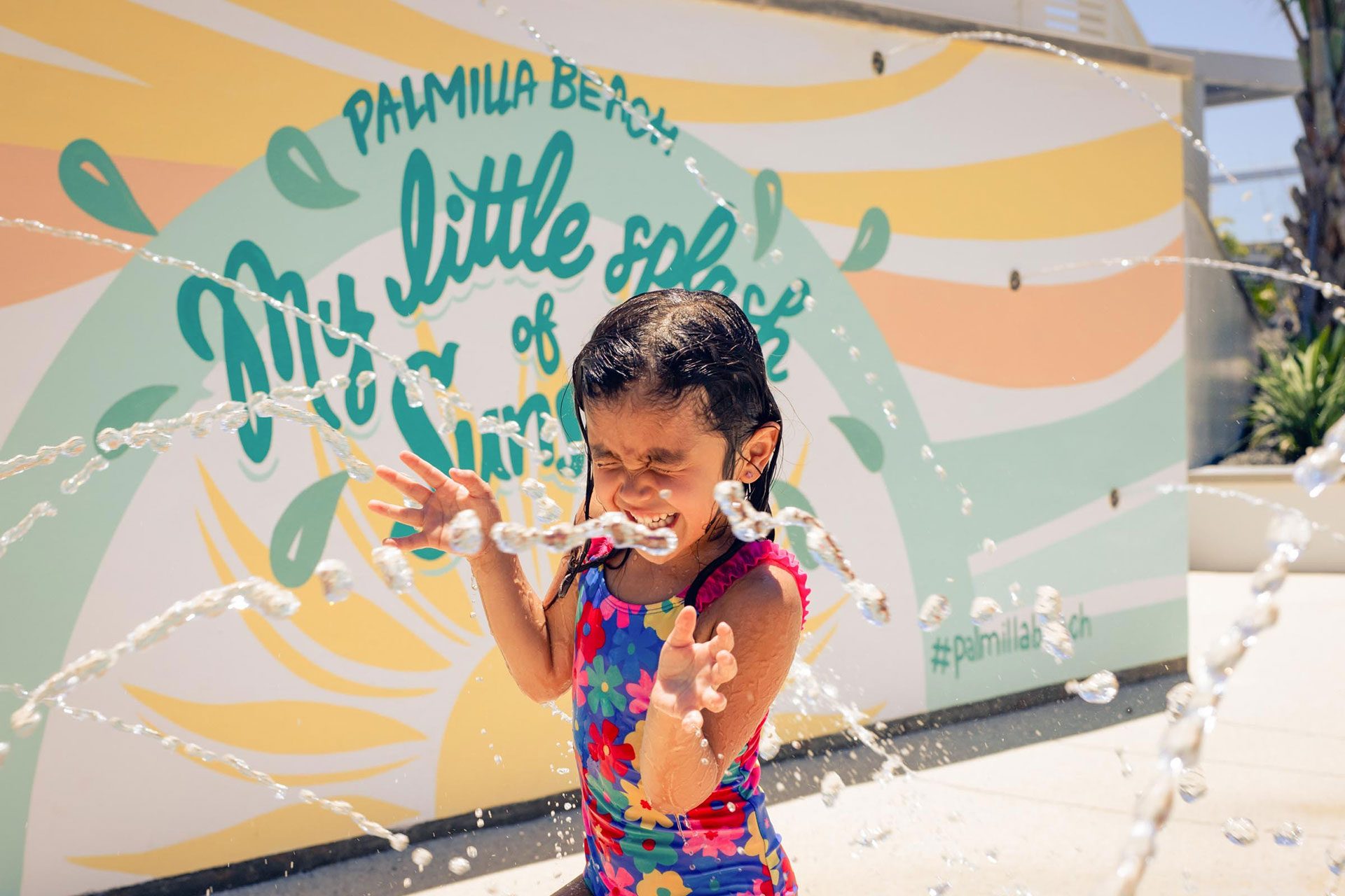 Girl playing in the splash pad at The Oasis