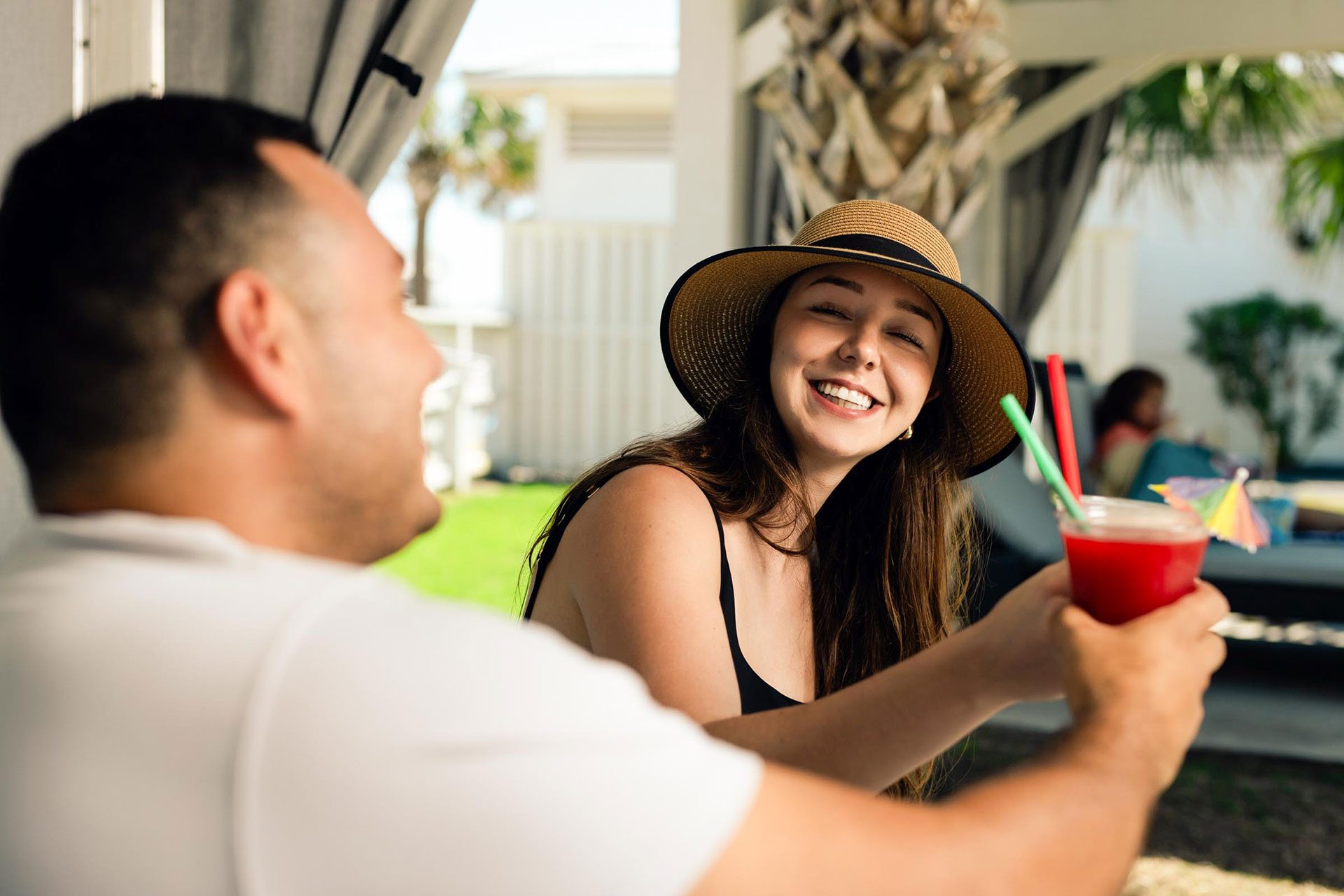 Couple sharing drinks in a cabana at The Oasis